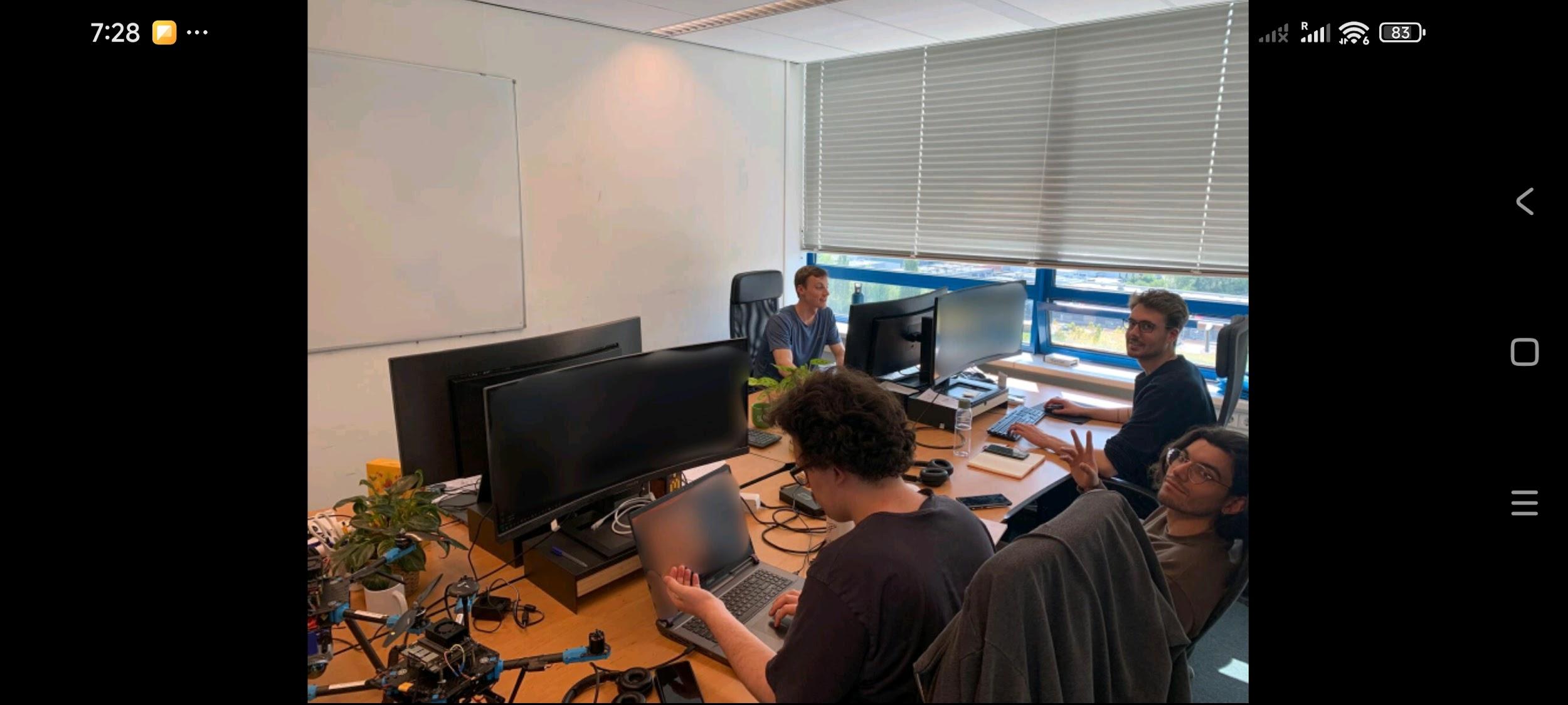 The Emergent Swarm Solutions team working in the TU Delft Aerospace Innovation Hub office, drone hardware on the desk